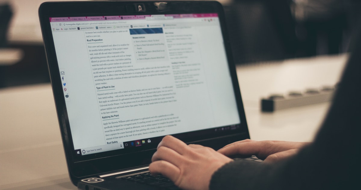 Pessoa digitando em laptop enquanto analisa conteúdo genérico de IA na tela