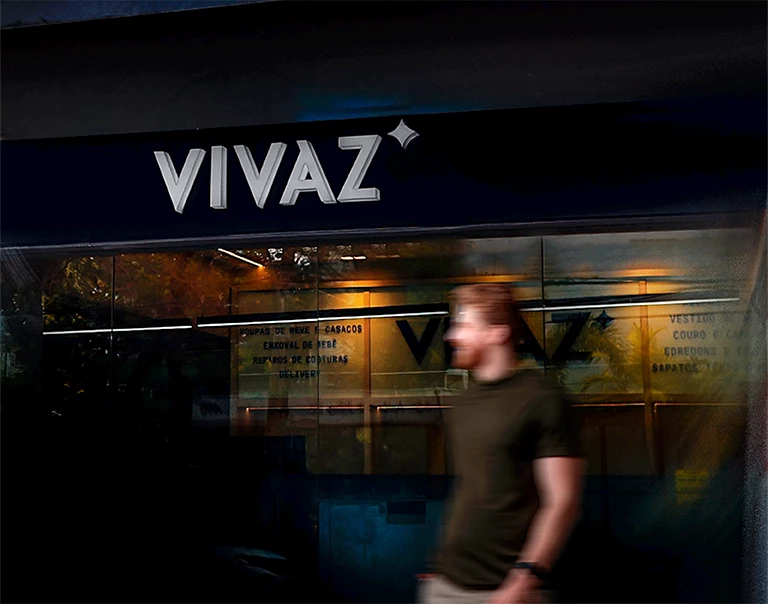 Fachada noturna da Vivaz Lavanderia em Recife, com tipografia clean iluminada e ambiente premium